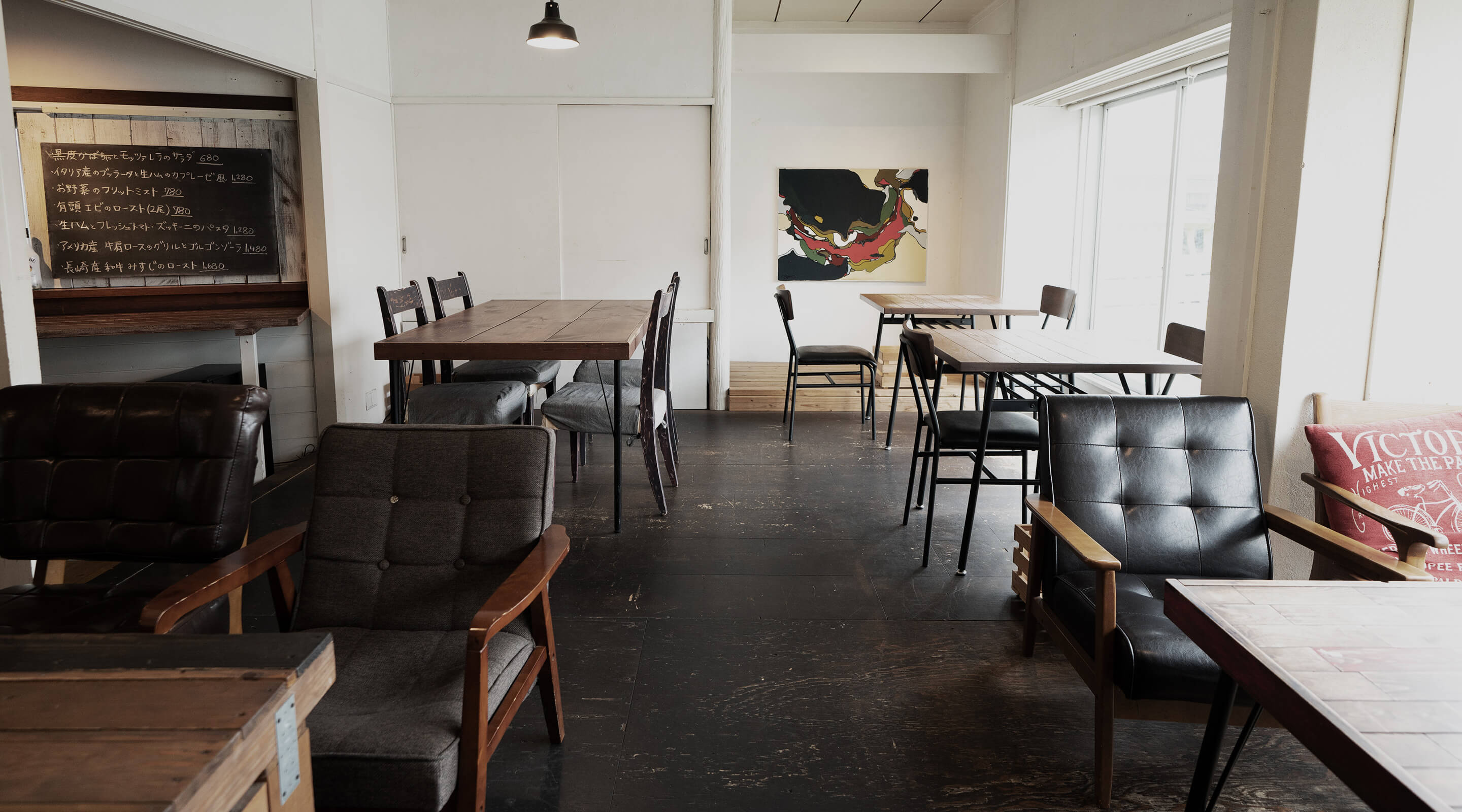 ヴィンテージウッドのテーブル席が並ぶカフェ店内写真