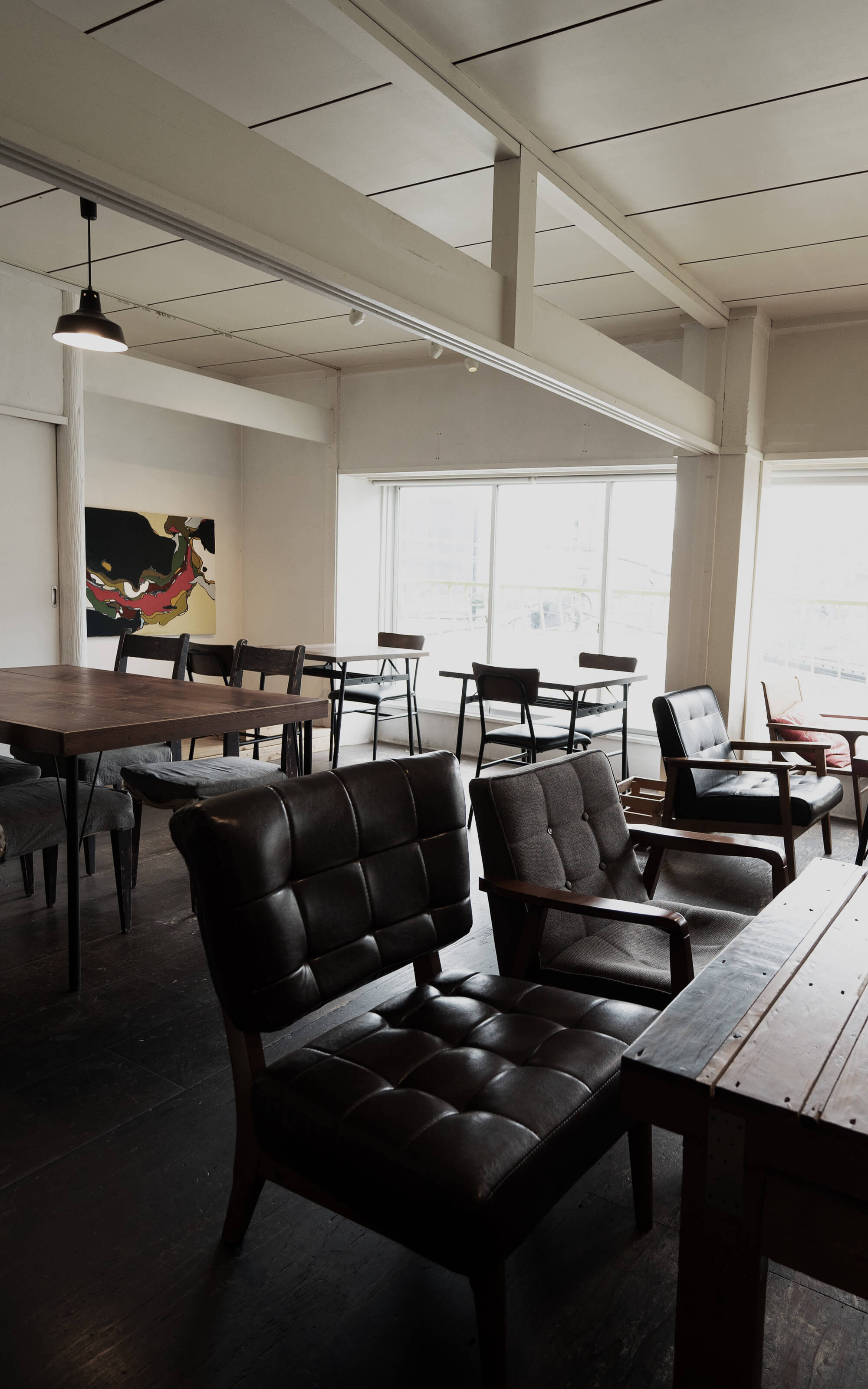 ヴィンテージウッドのテーブル席が並ぶカフェ店内写真