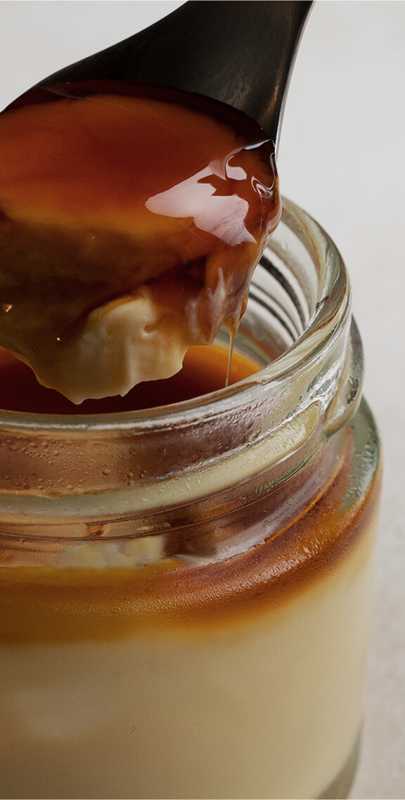 キャラメルソースが垂れるスプーンですくったトロトロのカタラーナの写真